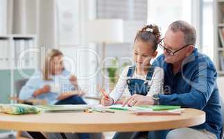 Make education a priority. a grandfather helping his grandchild with her homework at home.