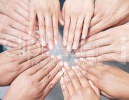 Coming together as one. Shot shot of a group of unidentifiable businesspeople joining their hands together in a unity.