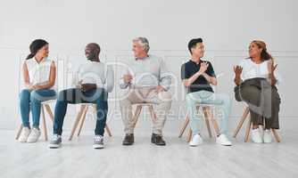 Talking about all the current hot topics. a group of diverse people talking to each other while sitting in line against a white background.