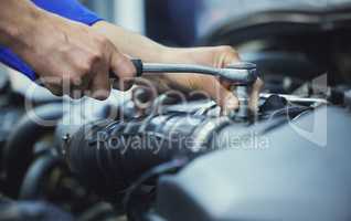 Nice and tight. an unrecognizable male mechanic working on the engine of a car during a service.