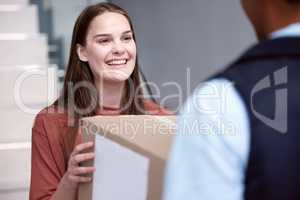 Spreading joy to everyone around. Shot of a woman accepting her delivery from the delivery man.