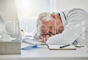 When work starts feeling overwhelming, take a nap. a mature doctor sleeping at his desk at work.
