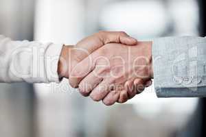 This handshake means new beginnings. Shot of two unrecognizable businespeople shaking hands in an office at work.