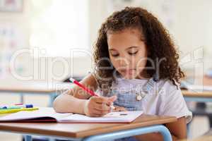 Staying focused in class. Shot of a preschooler colouring in class.