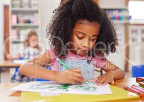 Hand-eye coordination and pencil grip add up to writing skills. a preschooler colouring in class.