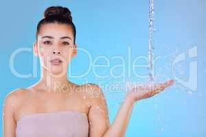 Its a deep, biological connection. Shot of a beautiful young woman being splashed with water against a blue background.