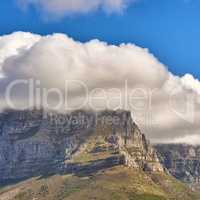 Clouds covering top of Table Mountain, Cape Town with copyspace. Cloud shape and shadow over rocky terrain on a sunny day, beautiful, calm nature in harmony with scenic views of plants and landscape
