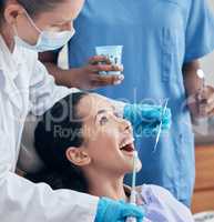 Open wide for me. a young woman having a procedure performed by her dentist.