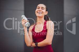 Hydration is the key. Cropped portrait of an attractive young female athlete drinking water while running outdoors.