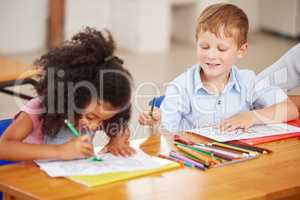 Learning to share is one of the skills we learn at preschool. preschool students colouring in class.