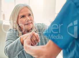 It is the courage to continue that counts. Shot of a young nurse helping her elderly female patient stand up.