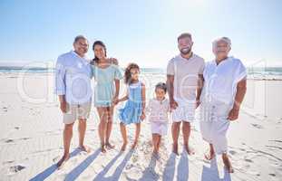 Multi generation family standing together at the beach. Mixed race family with two children, two parents and grandparents spending time together by the sea