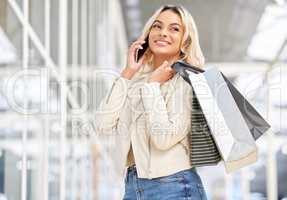 Come around and well party. a young woman using her smartphone to make a phone call while shopping.