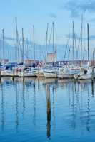 Group of boats docked in a harbor of Bodo. Scenic view of sailing yachts in cruise port and bay at dusk. Rippled water and sky in oceanside port for fishing or traveling abroad for vacation