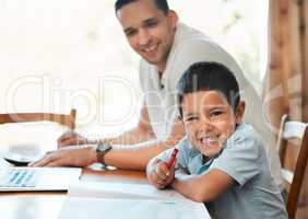 Excited preschooler boy drawing and writing with crayon at table at home while dad works remotely. Child sitting with parent during online education classes