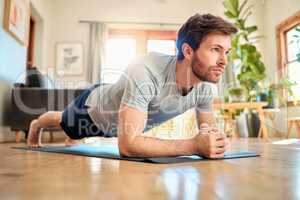 One fit young caucasian man doing elbow plank hold bodyweight exercise while training at home. Focused guy challenging himself to gain muscle, enhance upper body, core strength and increase endurance during workout