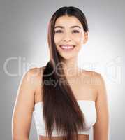 Focus on you. Studio portrait of a beautiful young woman showing off her long silky hair against a grey background.