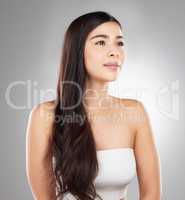 No off days for haircare. Studio shot of a beautiful young woman showing off her long silky hair against a grey background.