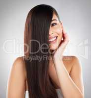 Lifes short, your hair doesnt have to be. Studio portrait of a beautiful young woman showing off her long silky hair against a grey background.