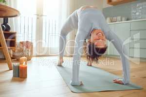 Beautiful young mixed race woman practicing yoga at home. Hispanic female doing pilates exercise as part of her workout. Working out to keep her mind and body healthy. Dedicated to a fitness lifestyle