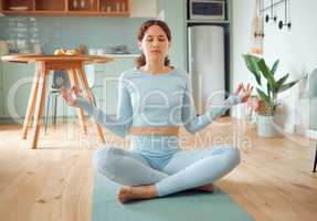 Beautiful young mixed race woman meditating in the asana position while practicing yoga at home. Hispanic female exercising her body and mind, finding inner peace, balance and clarity