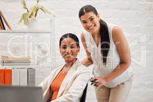 Portrait of a young happy mixed race businesswoman helping a colleague in a wheelchair to her office at work. Content hispanic businessperson with a disability being helped to her desk at work