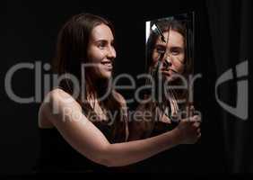You dont know me. a creepy woman grinning at her reflection in a broken mirror.