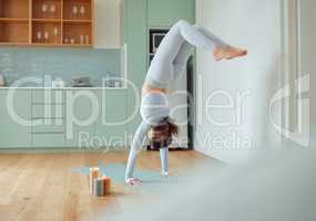 Beautiful young mixed race woman practicing yoga at home. Hispanic female doing pilates exercise as part of her workout. Working out to keep her mind and body healthy. Dedicated to a fitness lifestyle