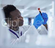 The blood holds the secrets. a young male scientist analysing a blood sample in a test tube.