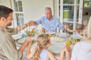 Blessing the food that was prepared. a family praying together before enjoying sunday lunch.