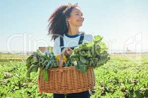 She never dreamed shed come this far. a young farmer holding a basket of freshly harvested veggies.