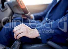 Driving at a safe speed and with caution. Closeup shot of an unidentifiable businessman changing gears while driving a car.
