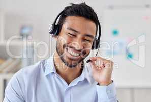 Face of happy mixed race call centre telemarketing agent with big smile talking on headset while working in office. Confident friendly businessman operating helpdesk for customer service sales support