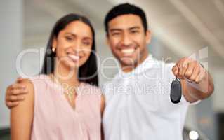 We just bought a new car. a young couple showing their car keys.