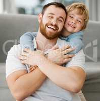 Cute little smiling caucasian boy hugging dad from behind at home. Carefree happy dad receiving love and affection from playful son. Man feeling special while enjoying special moments on fathers day