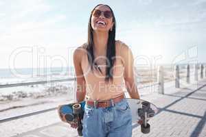 Zero boredom when Im on my board. a young woman hanging out at the promenade with her skateboard.