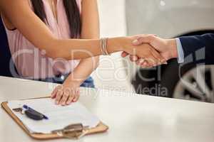 We offer financing too. a car salesman shaking hands with a woman after completing paperwork.