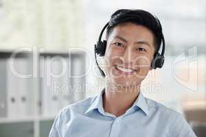 Asian businessman working in a call center and smiling in a bright office. Financial advisor wearing a headset. Customer service rep looking positive against a light copyspace background