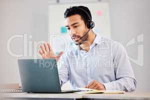Handsome mixed race male call center agent answering calls working on laptop in an office alone at work. Hispanic Customer service agent on a call, ESL teacher working remote against bright copyspace