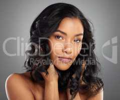 Give your hair some volume. Cropped portrait of an attractive young woman posing in studio against a grey background.