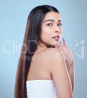 My growing journey. Studio portrait of a beautiful young woman showing off her long silky hair against a blue background.