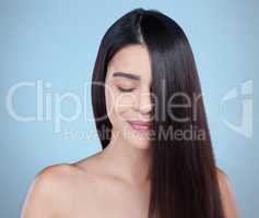 Love the locks youre in. Studio shot of a beautiful young woman showing off her long silky hair against a blue background.