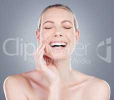 Diminishing fine lines and wrinkles. Studio shot of an attractive mature woman touching her face against a grey background.