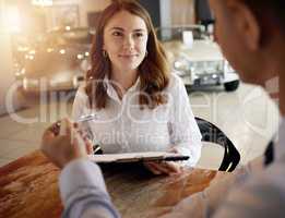 Shes very happy with the deal. an attractive young female customer talking to a car salesman in his office at the dealership.