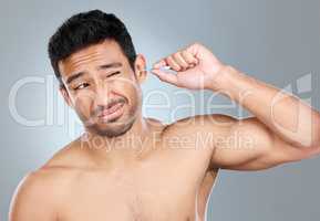 Im trying not to go too deep. a man using a cotton bud to clean his ears.