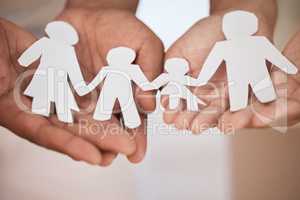 Closeup of a couples hands holding paper cutout of a perfect family. Symbol of home cover, insurance, health, adoption, custody, law, safety, security protection, foster, adoption family home concept