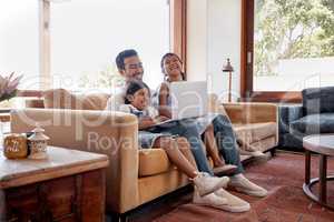 Lazy laptop days. Full length shot of a handsome young man and his two daughters using a laptop while sitting on the sofa at home.