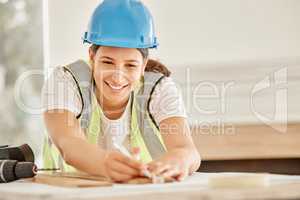 Im happy with these measurements. Shot of an attractive young construction worker standing alone and using a ruler to measure a beam of wood.