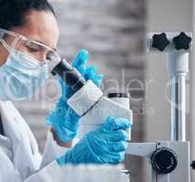 Notices the changes as they appear. a young scientist using a microscope in a lab.