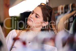 You dont need a reason to spoil yourself. an attractive young woman checking an item of clothing in a store.